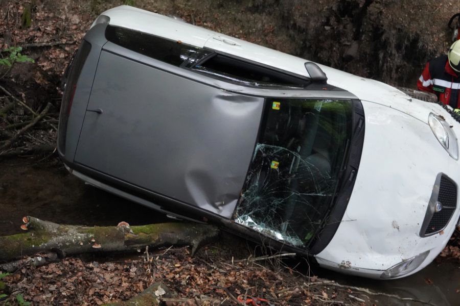 In Hinwil ZH muss ein Auto aus einem Bachbett geborgen werden.