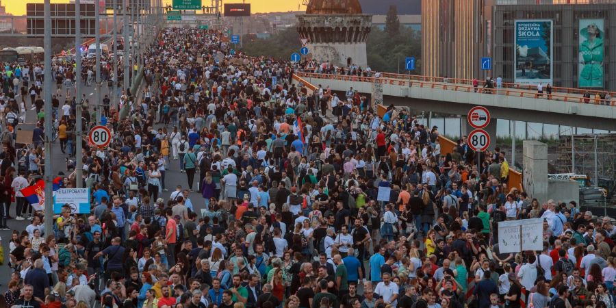 Menschen marschieren während einer Demonstration auf einer Autobahn in Belgrad.