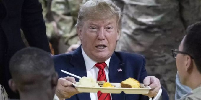 US-Präsident Donald Trump hält bei einem Besuch von amerikanischen Truppen ein Tablett mit Essen in der Hand. Foto: Alex Brandon/AP/dpa trump