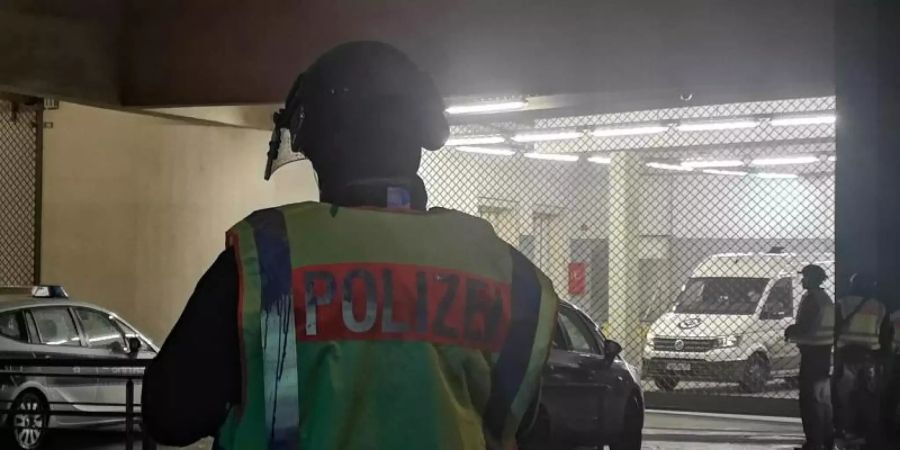 Polizisten stehen nach dem Überfall auf einen Geldtransporter vor einem Einkaufszentrum in Berlin-Treptow. Foto: ---/dpa