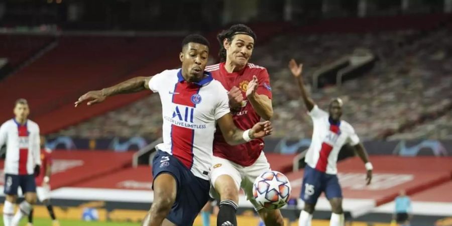 Zweikampf um den Ball zwischen Edinson Cavani (r) von Manchester United und Presnel Kimpembe von Paris Saint-Germain. Foto: Dave Thompson/AP/dpa