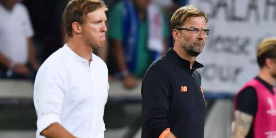 Treffen mit ihren Teams in Budapest aufeinander: Leipzig-Coach Julian Nagelsmann (l) und Liverpools Jürgen Klopp. Foto: picture alliance / Uwe Anspach/dpa
