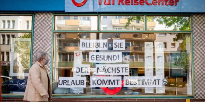Eine Passantin mit Maske geht an einem Reisebüro vorbei. Der Betreiber hat den Hinweis «Bleiben Sie gesund! Der nächste Urlaub kommt bestimmt» in sein Schaufenster gehängt. Foto: Kay Nietfeld/dpa Eine Passantin mit Maske geht an einem Reisebüro vorbei. Der Betreiber hat den Hinweis «Bleiben Sie gesund! Der nächste Urlaub kommt bestimmt» in sein Schaufenster gehängt. Foto: Kay Nietfeld/dpa