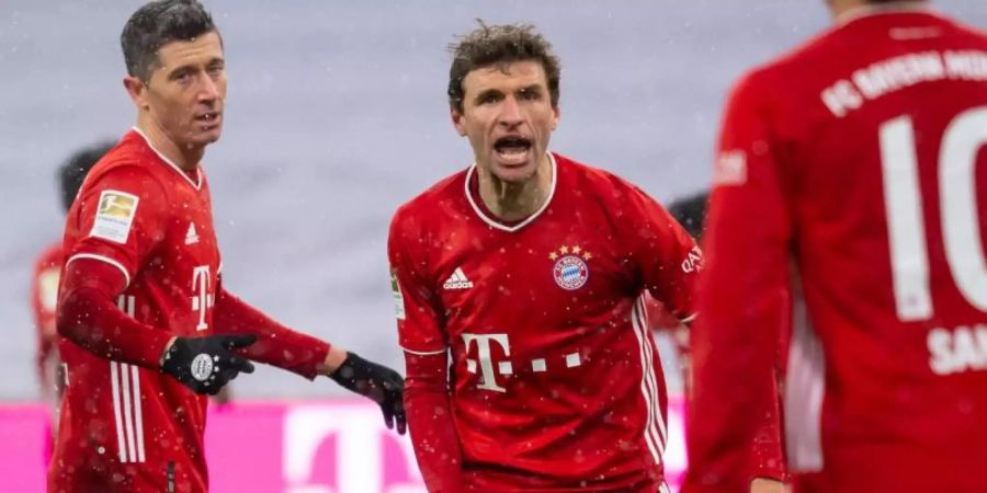 Robert Lewandowski, Thomas Müller und Leroy Sané (l-r) jubeln über das Bayern-Tor zur 2:1-Führung gegen den SC Freiburg. Foto: Sven Hoppe/dpa