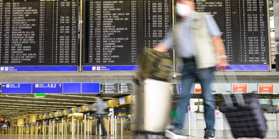 Ein Mann geht durch die leere Abflughalle am Frankfurter Flughafen. Foto: Andreas Arnold/dpa