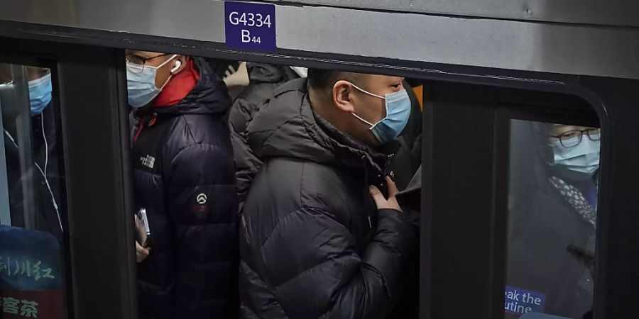 dpatopbilder - Pendler in Peking drängen sich in eine U-Bahn während der Hauptverkehrszeit. Foto: Andy Wong/AP/dpa