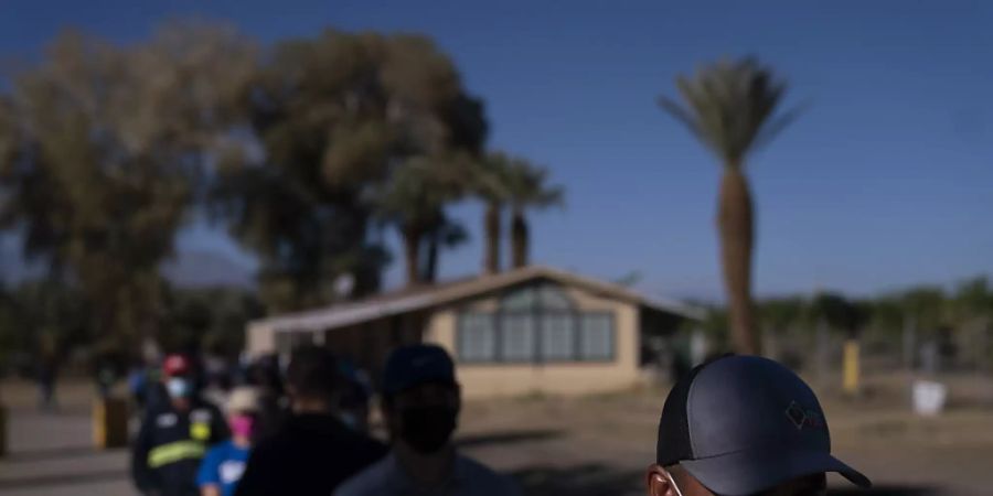 Eingewanderte Landarbeiter tragen Mund-Nasen-Bedeckungen und warten in einer Schlange, um die Corona-Impfung zu erhalten. Verbände warnen davor, dass Millionen Einwanderer zu den am schwierigsten zu erreichenden Menschen während der grössten Impfkampagne in den USA gehören könnten. Foto: Jae C. Hong/AP/dpa