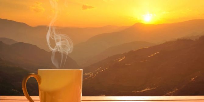 Kaffeetasse Dampf Sonnenaufgang Bergkulisse