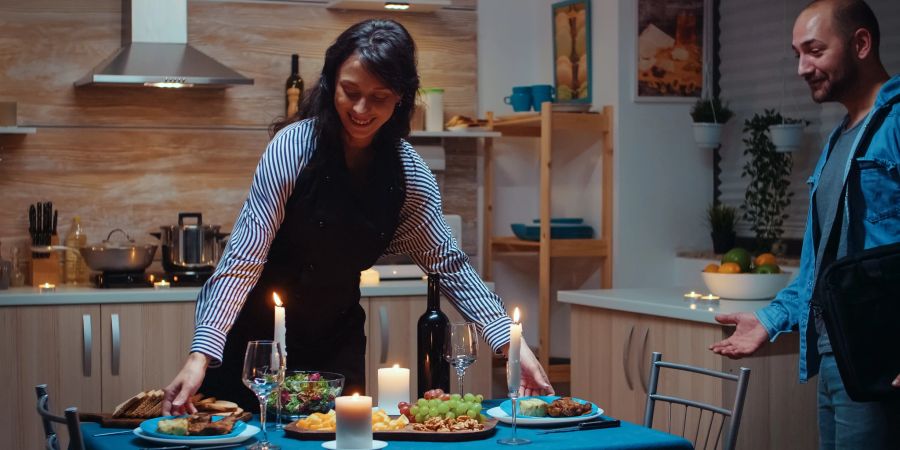 frau bereitet essen vor, mann kommt von der arbeit