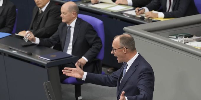 CDU-Chef Friedrich Merz (rechts) spricht im Bundestag zur Vertrauensfrage, während Bundeskanzler Olaf Scholz im Hintergrund zuschaut, am 16. Dezember 2024 in Berlin. Olaf Scholz Friedrich Merz