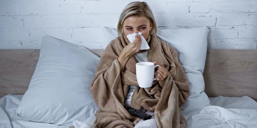 frau mit erkältung im bett