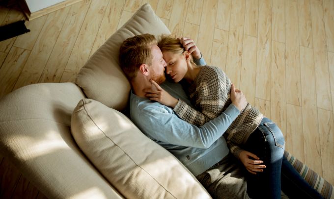 Konflikte sind normal, doch Beziehung erfordern auch Kompromissbereitschaft. Kuschelndes Paar auf Sofa