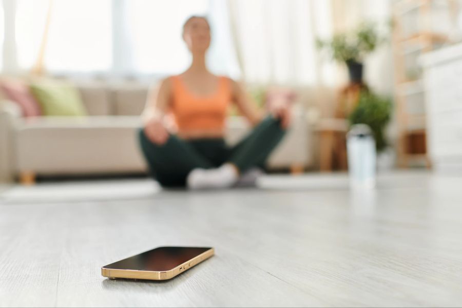 Frau, Yoga, Smartphone im Vordergrund