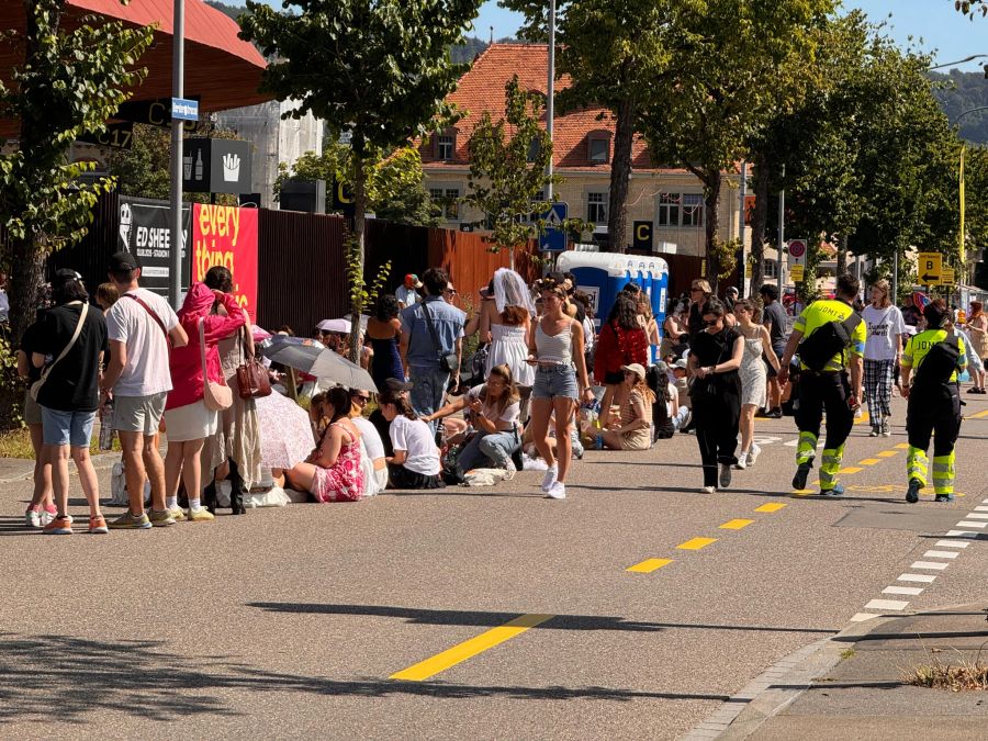 Bei 27 Grad harren die «Swifties» vor dem Zürcher Letzigrund-Stadion aus.