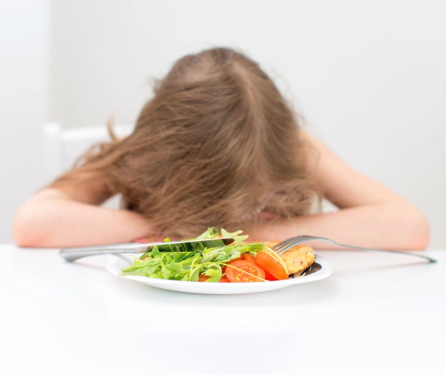 Salat, junger Mensch mit Kopf auf dem Tisch