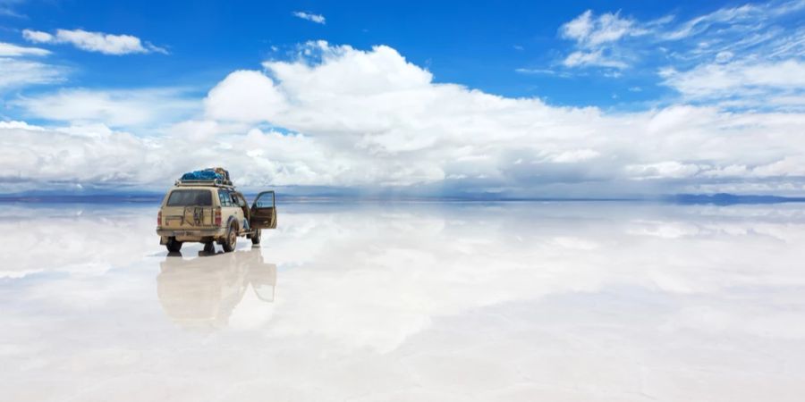 Salar de Uyuni Geländewagen Wolken Spiegelung