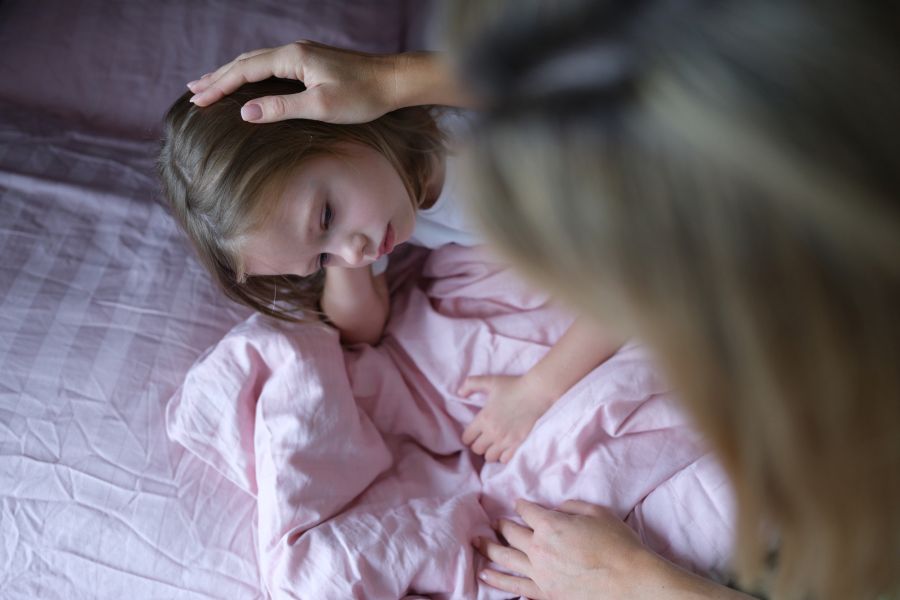 Mutter tröstet Tochter im Bett