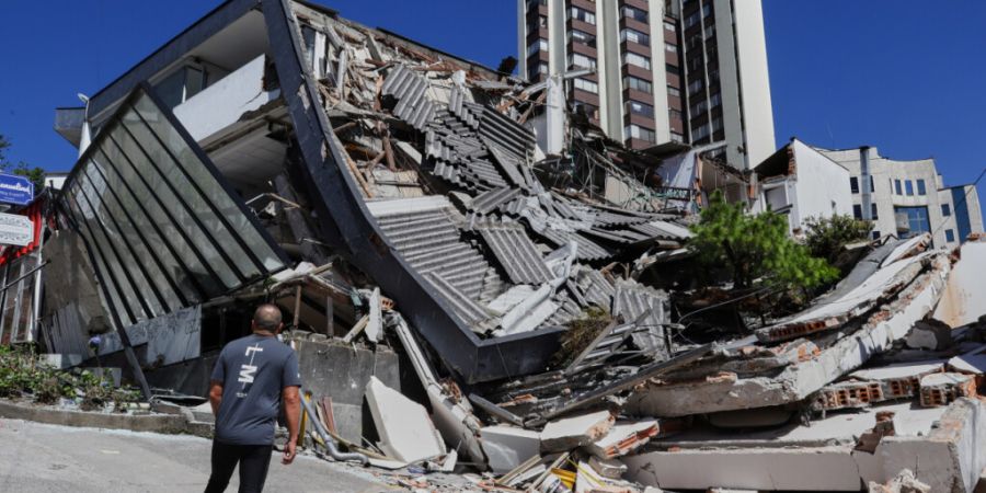 Ein Mann blickt auf ein eingestürztes Gebäude, nachdem ein Erdbeben die Stadt Manizales in Kolumbien erschüttert hatte. Foto: Dario Cardona/AP/dpa