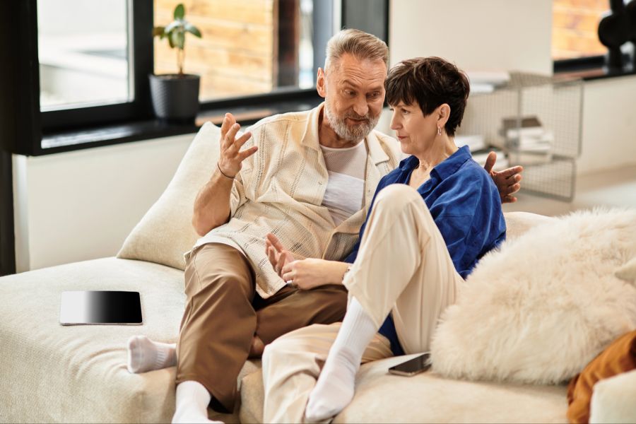 Mann und Frau auf einem Sofa, Mann spricht Frau gut zu
