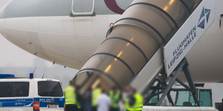 ARCHIV - Menschen besteigen ein Flugzeug der Qatar Airways, vor dem Fahrzeuge der Bundespolizei stehen, auf dem Vorfeld am Flughafen Leipzig/Halle. (zu dpa: «Fast zwei Drittel aller ge...