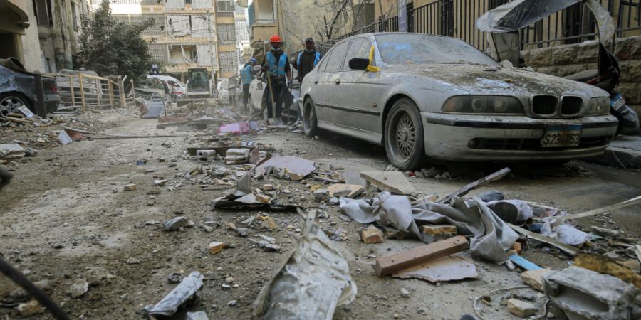 dpatopbilder - Arbeiter räumen Trümmer von einer Straße in Beirut, nachdem ein Wohnhaus von einem israelischen Luftangriff getroffen wurde. Foto: Marwan Naamani/dpa