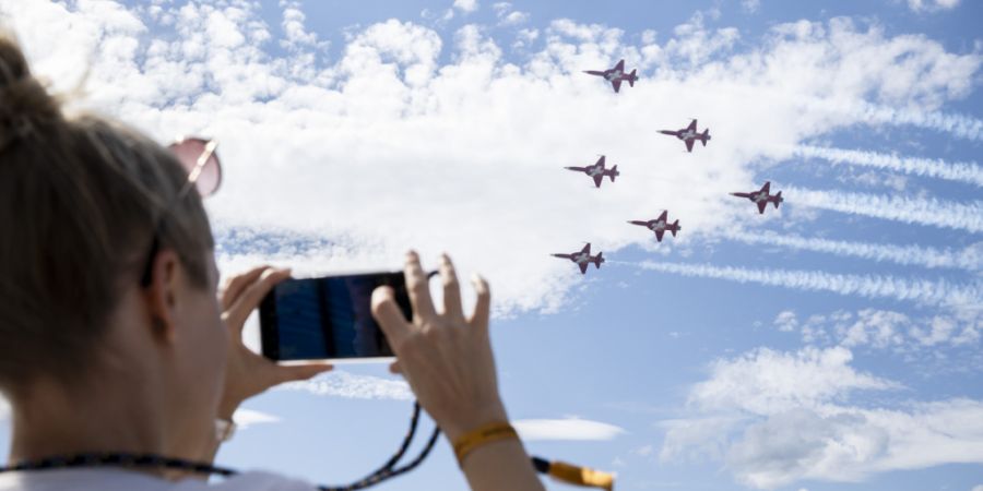 Eine Zuschauerin fotografiert am 1. September 2023 die Flugshow der Patrouille Suisse anlässlich des 75-Jahre-Jubiläums des Flughafens Zürich. (Archivbild)