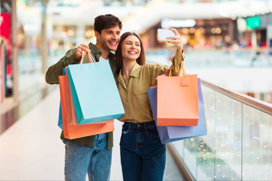 Mann und Frau machen Selfie beim Shoppen