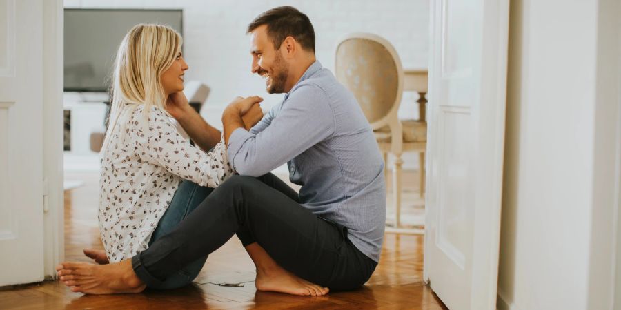 Frau und Mann sitzen zusammen auf dem Boden