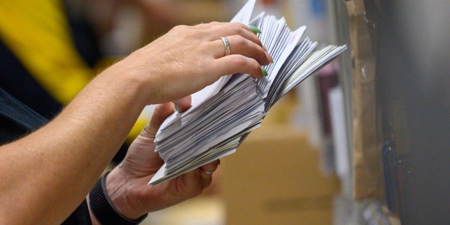 Eine Mitarbeiter der Deutschen Post sortiert in einem Zustellstützpunkt der Post Briefe.