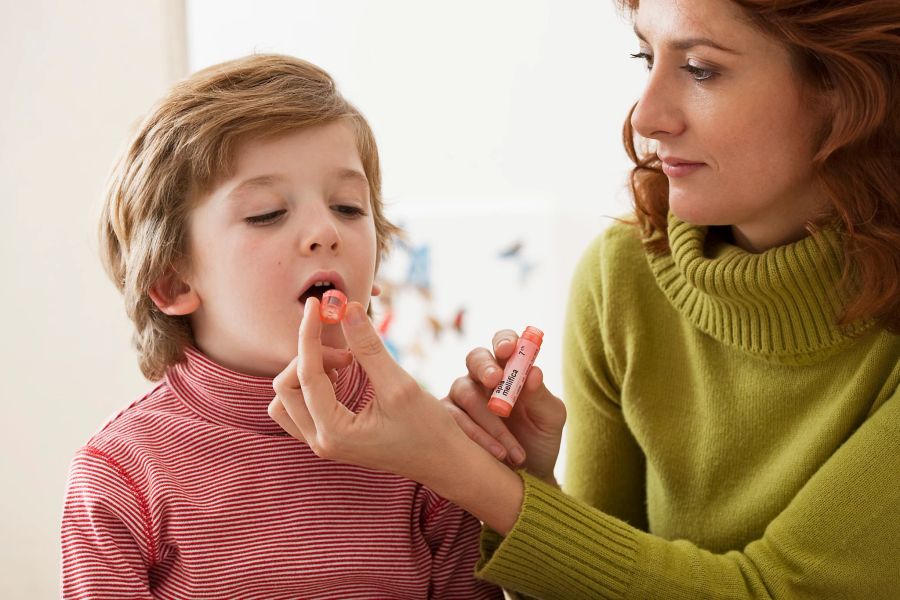 Mutter verabrreicht Kind Globuli