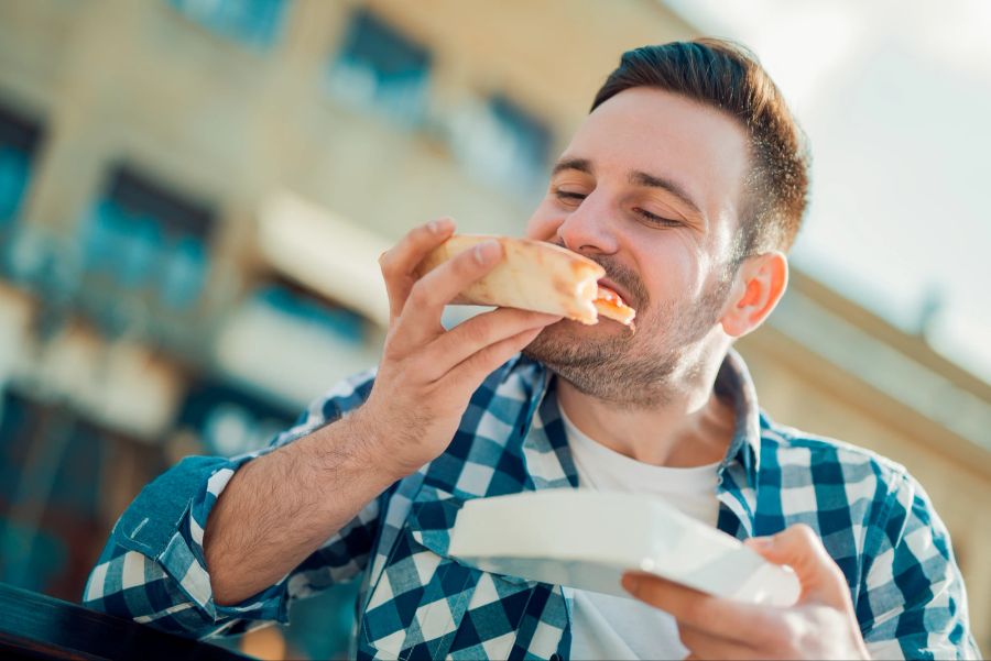 Mann isst Pizzastück