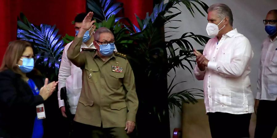 Raul Castro (M.), Erster Sekretär der Kommunistischen Partei und ehemaliger Präsident, winkt, während der kubanische Präsident Miguel Diaz-Canel (r) im Kongresspalast applaudiert. Foto: Ariel Ley Royero/ACN/dpa