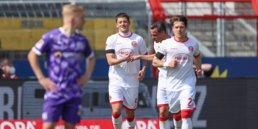 Düsseldorfs Torschütze Dawid Kownacki (3.v.r) feiert seinen Treffer zum 2:0 in Osnabrück mit den Teamkollegen Edgar Prib (2.v.r) und Leonardo Koutris. Foto: Friso Gentsch/dpa
