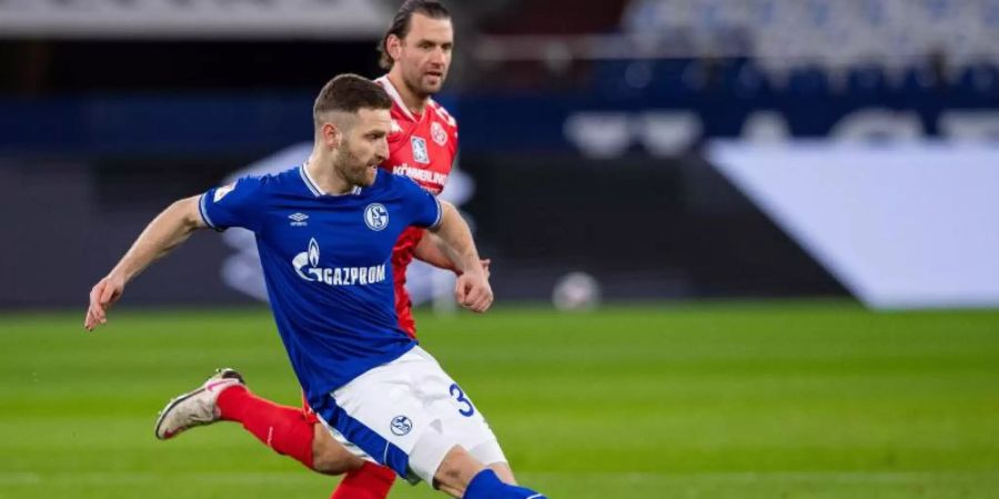 Schalkes Shkodran Mustafi (l) kommt vom Mainzer Adam Szalai bedrängt zum Schuss. Foto: Guido Kirchner/dpa