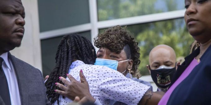 Eric Garners Mutter, Gwen Carr umarmt Andrew Brown Jr.'s Sohn Khalil Ferebee, Mitte, während die Anwälte von Browns Familie eine Pressekonferenz abhalten, um die Ergebnisse der Autopsie bekannt zu geben. Andrew Brown