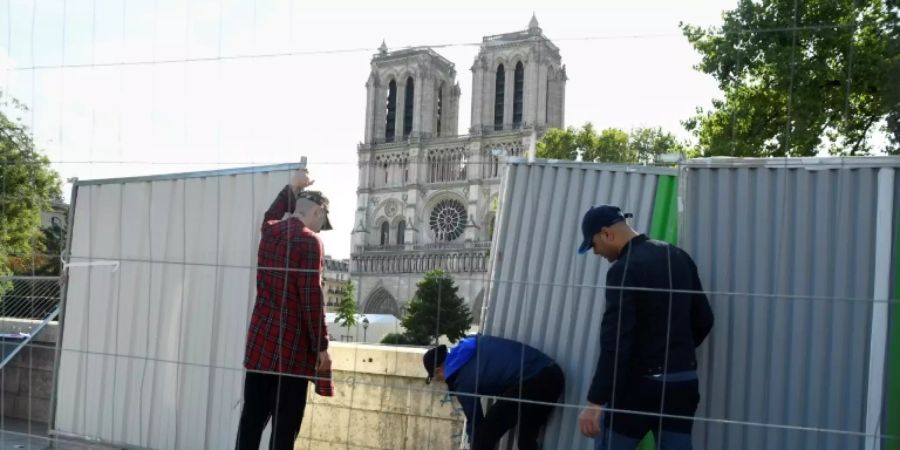 Arbeiter installieren Bauwände vor Notre-Dame