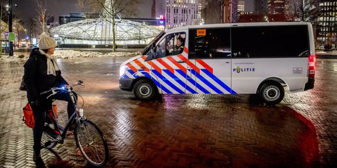 Polizisten im Streifenwagen sprechen im Februar 2021 eine Frau an, die am Abend noch in Rotterdam unterwegs ist. Coronavirus - Niederlande