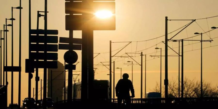Ein Radfahrer fährt über die Deutzer Brücke in Köln. Die Zahl der Corona-Neuinfektionen steigt. Foto: Oliver Berg/dpa