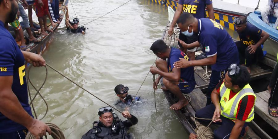Taucher steigen nach einem Schiffsunglück für die Bergung von Opfern in den Fluss Buriganga. Foto: Str/Xinhua/dpa