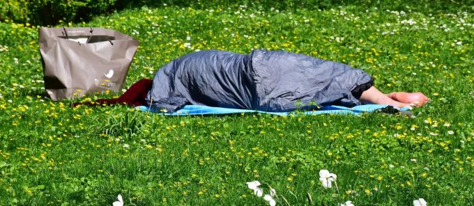 Schlafsäcke, besonders aus dem Militär, helfen den Obdachlosen durch den Winter. Obdachloser in einem Schlafsack
