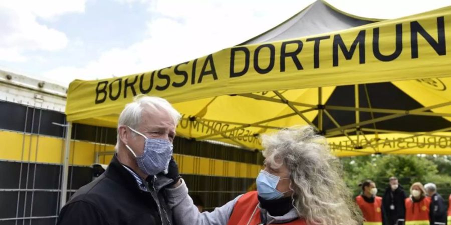 Beim Mitglied einer TV-Crew wird vor dem Einlass ins Stadion die Temperatur gemessen. Foto: Martin Meissner/AP-Pool/dpa