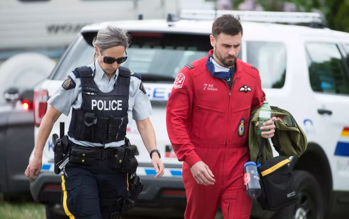 Joel Wilson, Pilot der kanadischen Kunstflugstaffel «Snowbirds», geht mit einer Polizistin an der Absturzstelle eines «Snowbirds»-Jets vorbei. Absturz von Jet