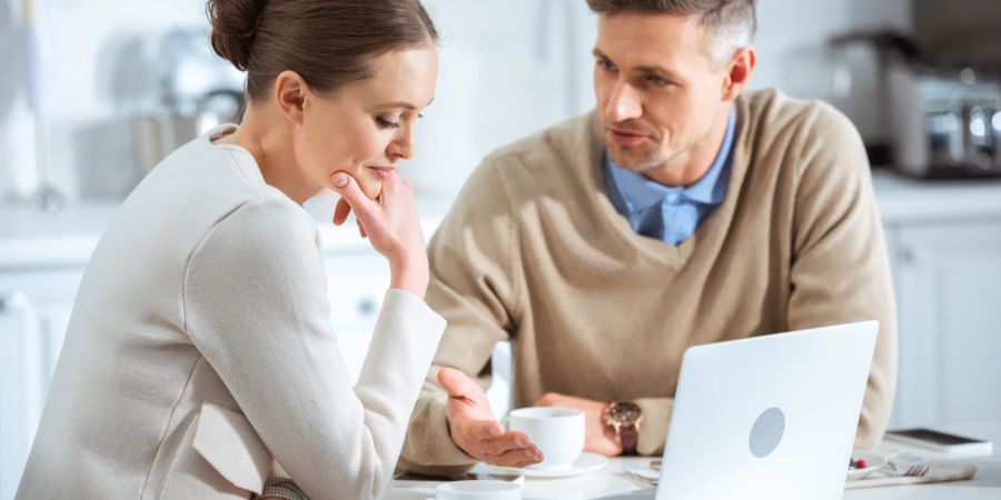 Mann und Frau unterhalten sich an Tisch