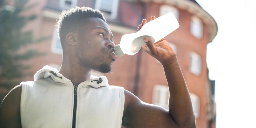 sportlicher mann trinkt wasser