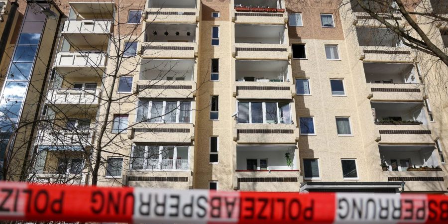 Absperrband der Polizei hängt nach dem Brand im Leipziger Stadtteil Paunsdorf vor dem Plattenbau.
