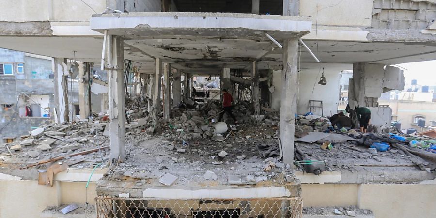 Palästinenser begutachten die Schäden und Trümmer der zerstörten Häuser nach israelischen Luftangriffen auf mehrere Häuser in der Stadt Rafah. Foto: Mohammed Talatene/dpa