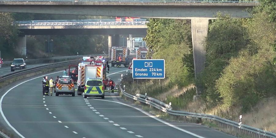 Feurwehrautos stehen auf der A31. Ein Waldbrand bei Dorsten hat zur Sperrung der Autobahn in Fahrtrichtung Norden geführt.