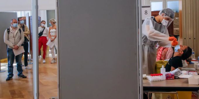 Eine Szene aus Paris: Ein Mitarbeiter des Gesundheitswesens nimmt einen Nasenabstrich für einen Covid-19-Test, während weitere Menschen in einer Schlange anstehen. Coronavirus - Frankreich