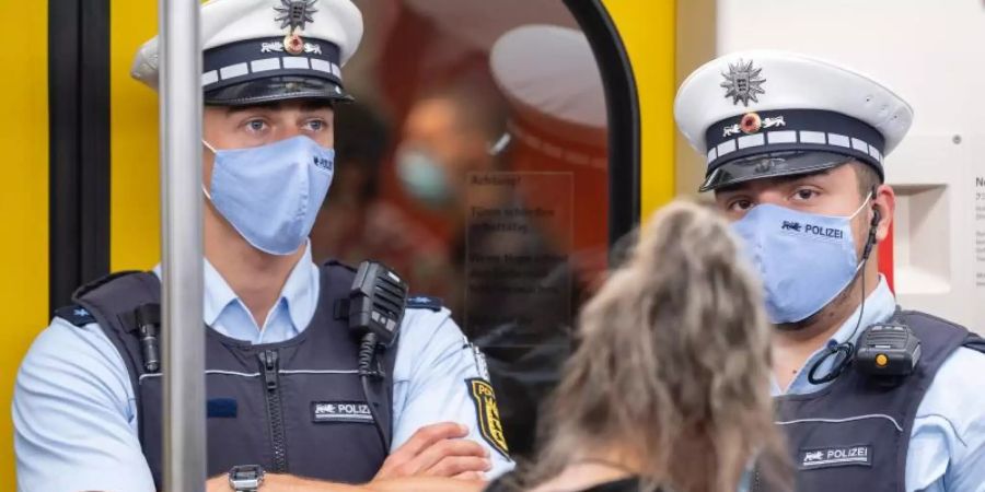 Polizeibeamte kontrollieren in einer Stuttgarter U-Bahn die Einhaltung der Maskenpflicht. Foto: Sebastian Gollnow/dpa