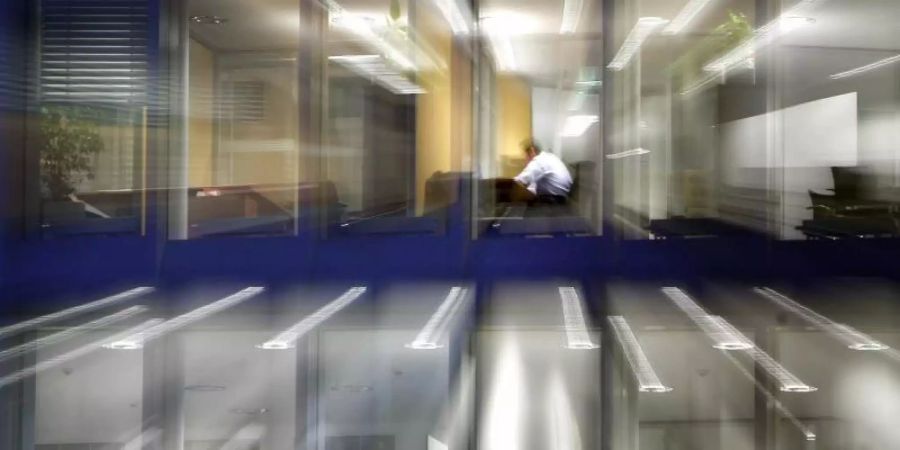 Nach Einbruch der Dunkelheit sitzen Angestellte noch in Büros und arbeiten (Aufnahme mit Zoomeffekt). Der Immobilien- und Handelskonzern Signa glaubt trotz des Homeoffice-Booms in der Corona-Krise an die Zukunft des Büros. Foto: Frank Rumpenhorst/dpa